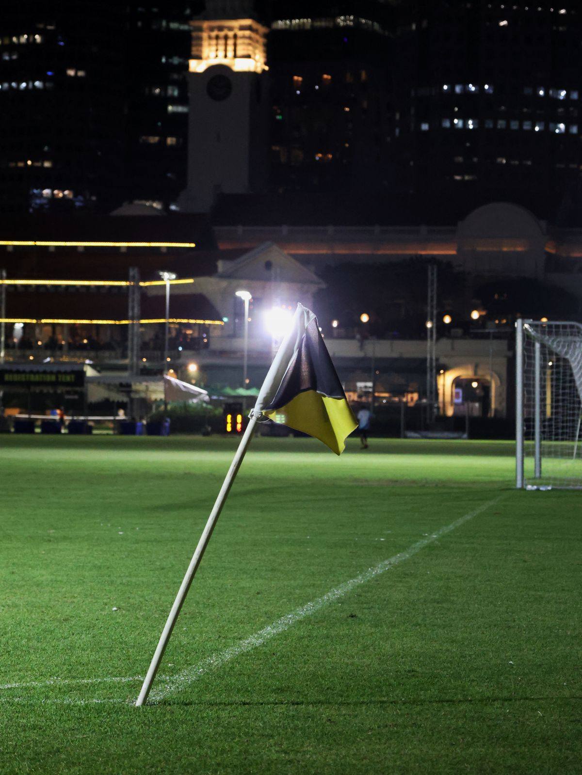Lapangan sepak bola malam hari dengan lampu stadion menyala